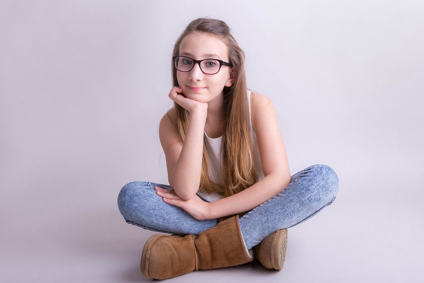 Portrait of a teenage girl in a studio with backdrop and lighting equipment